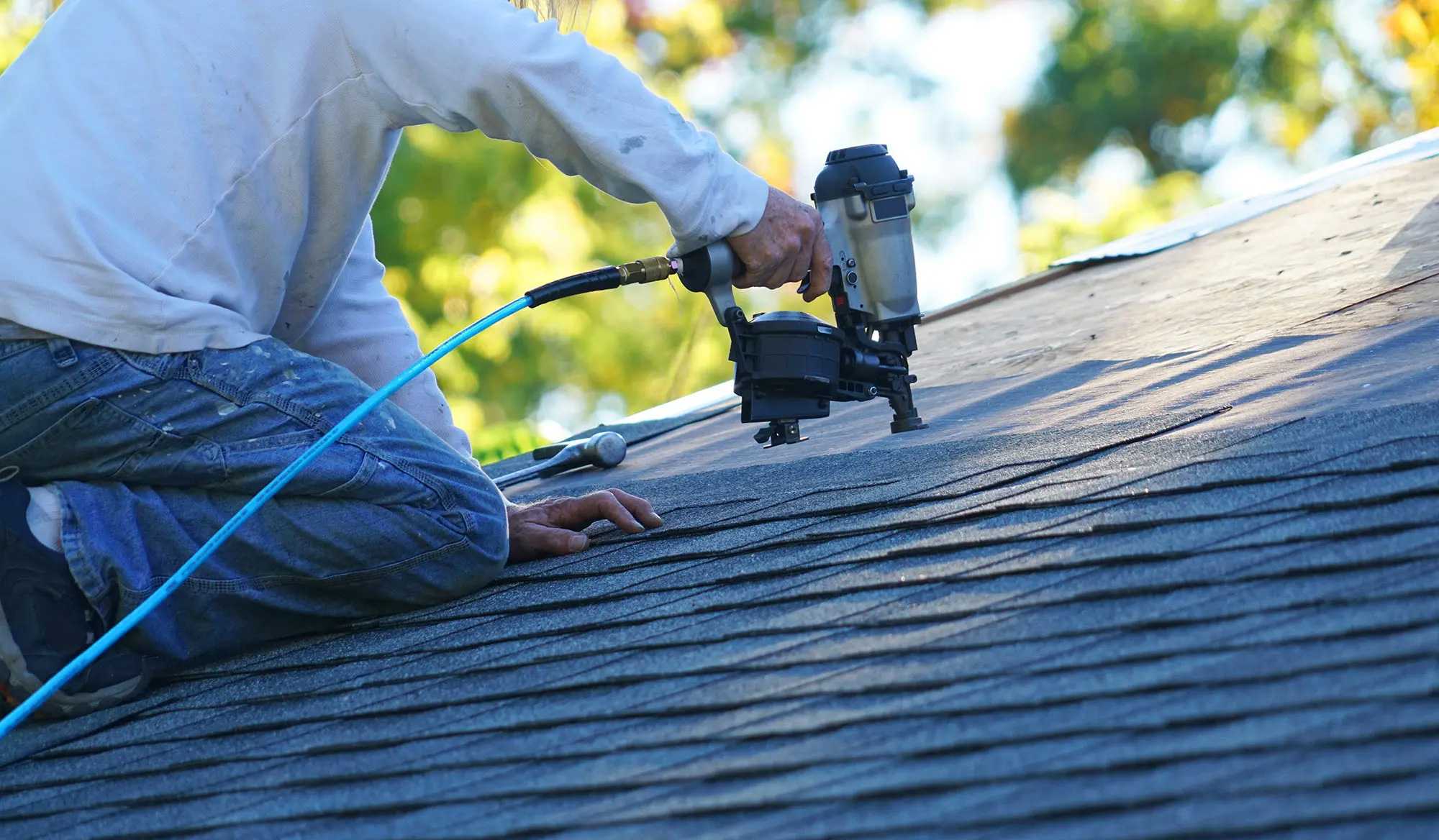 roofer installing shingles on asphalt roof